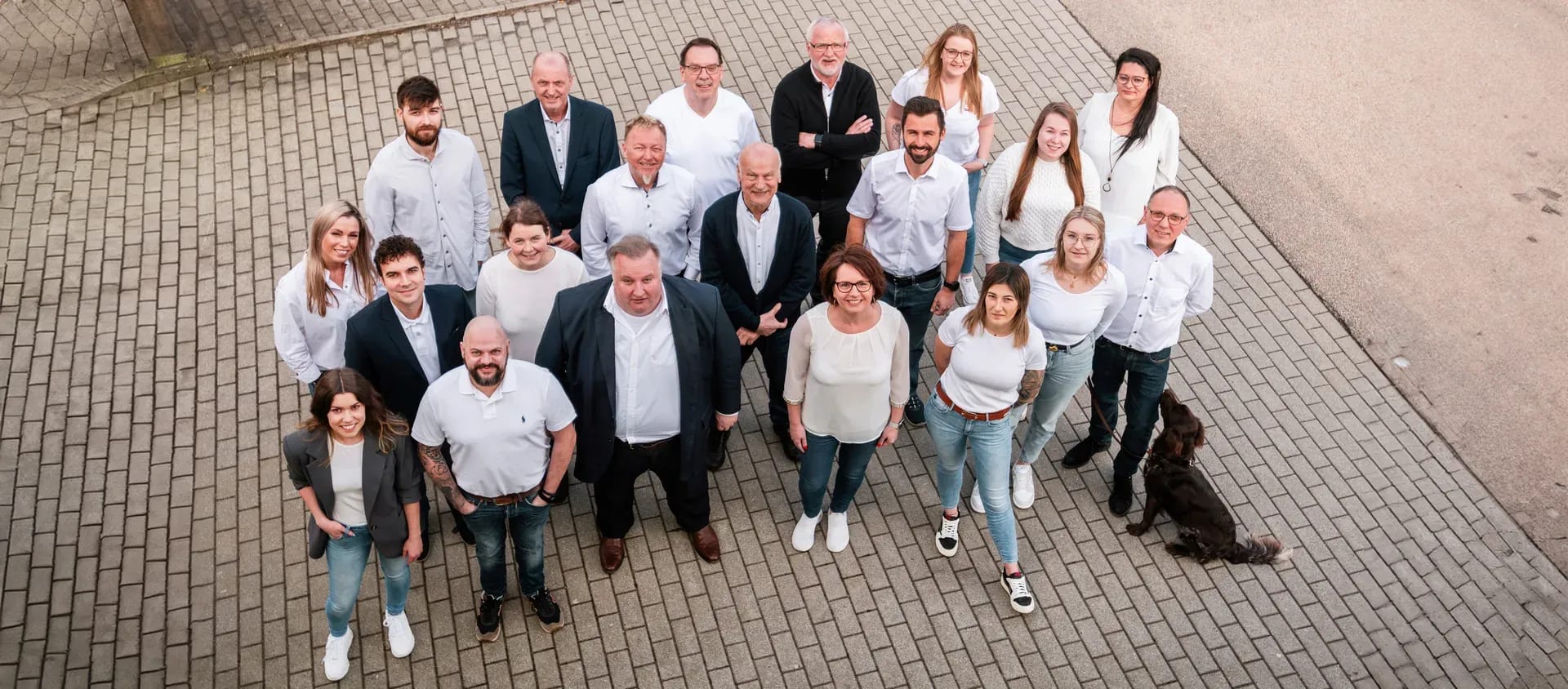 Das Team der UTB, von oben fotografiert auf einem gepflasterten Platz